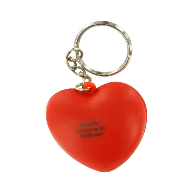 A red heart-shaped stress reliever attached to a metal keyring, featuring a logo.