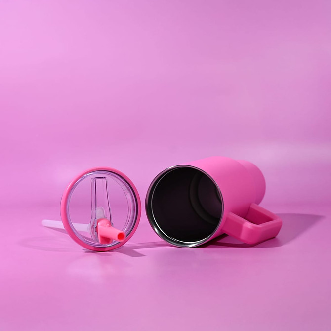 A pink 1.2L tumbler with a removable lid and straw, set against a pink background. It features a handle and a logo.
