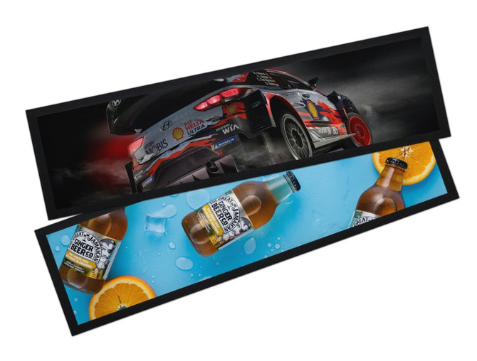 A bar runner featuring a racing car design and images of beer bottles with slices of orange, set against a blue background.
