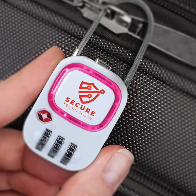 A hand holds a pink and white TSA lock with a logo, designed for securing luggage.
