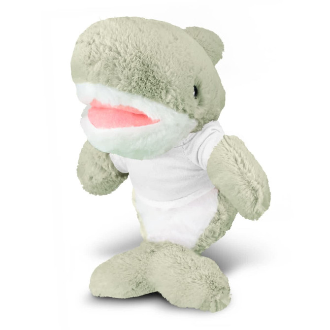 A grey-green shark plush toy with a white tummy and a smile, wearing a plain white t-shirt. It has a logo on it.