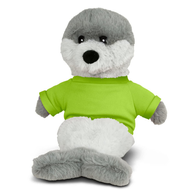A plush toy seal with grey and white fur, wearing a bright green shirt. It has a friendly expression and a branding logo.