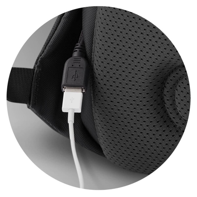 A close-up of a grey backpack featuring a USB port and a white charging cable connected.