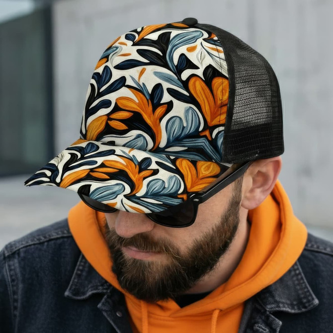 A mesh cap featuring a vibrant floral pattern in orange, blue, and cream, worn by a man with sunglasses.
