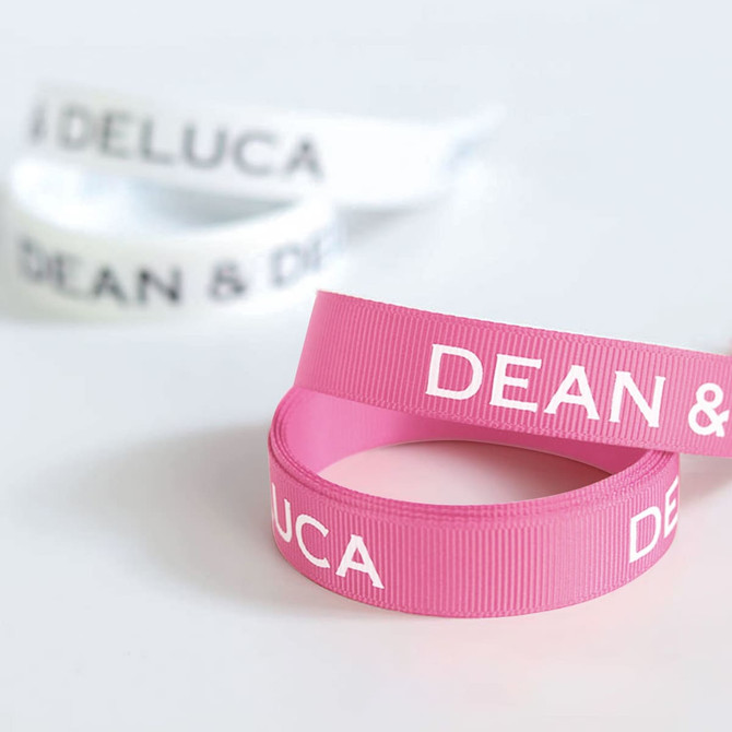 Ribbed fabric ribbons in pink and white, featuring text and a logo. Each ribbon is 22mm in width.