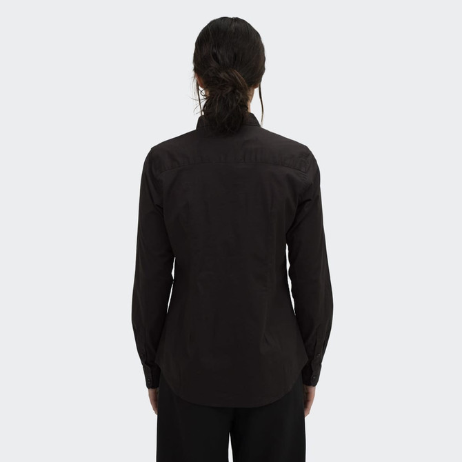 A women's black button-up poplin shirt featuring long sleeves and a fitted design, with a simple logo on the back.