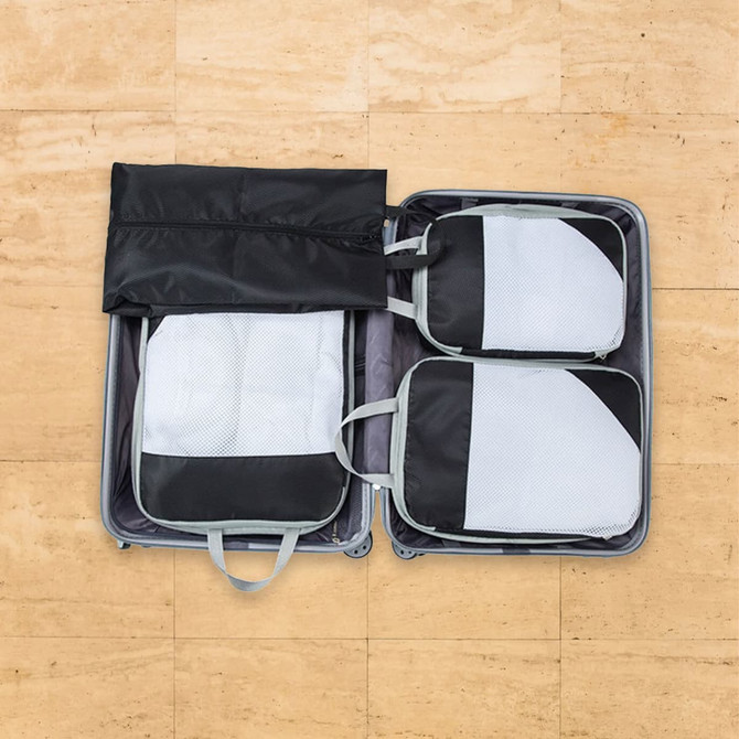 Packing cubes in black and grey arranged inside a suitcase, featuring mesh panels and handles for easy access.