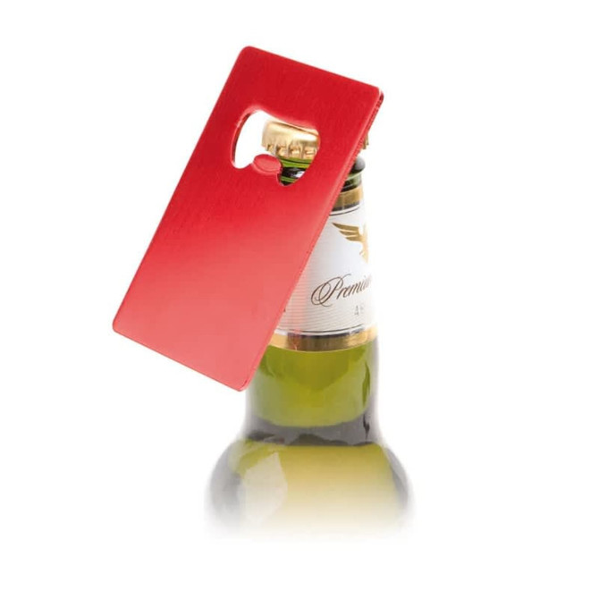 A red bottle opener in a rectangular shape is positioned on top of a drink bottle. It features a logo.
