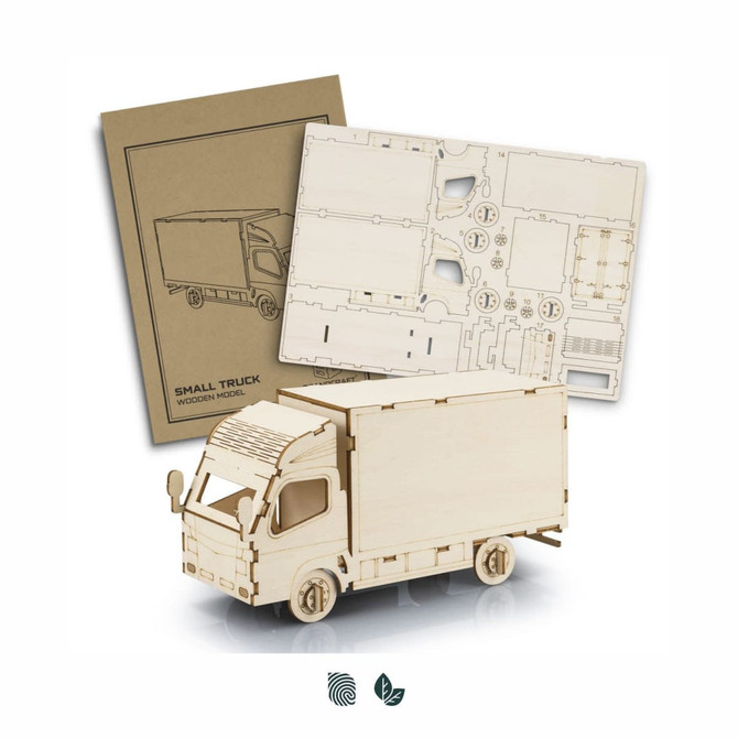 A wooden model of a small truck in natural light wood, accompanied by assembly instructions and cut-out pieces.