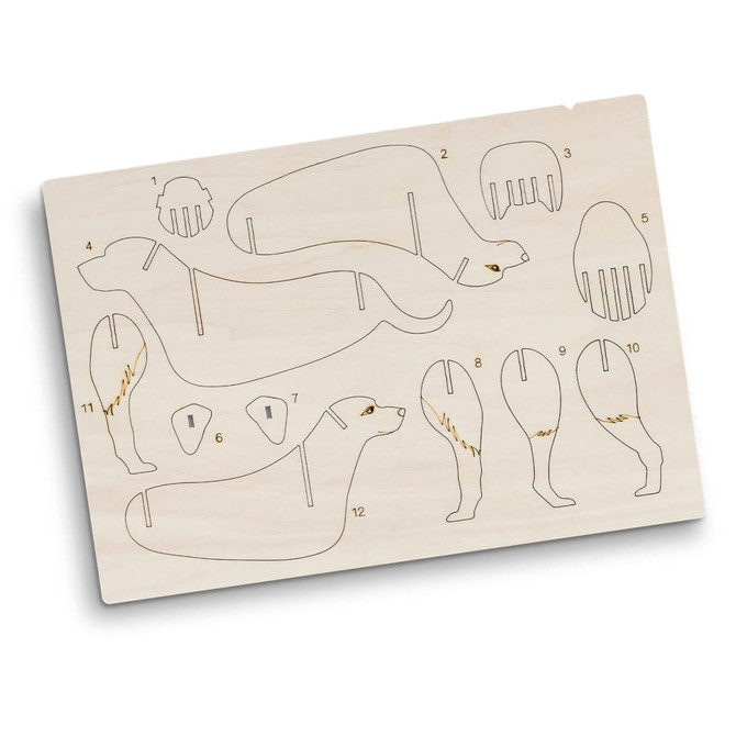 A wooden model kit featuring dog parts, with laser-cut outlines on a light wooden board.