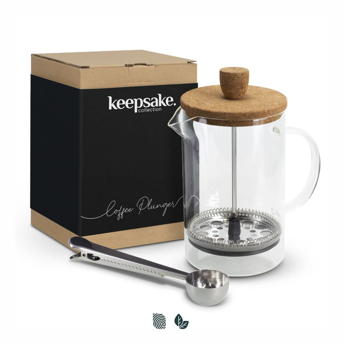 A transparent coffee plunger with a cork lid and stainless steel components, packaged in a branded box alongside a measuring spoon.