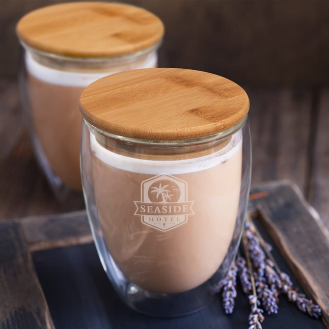 A drink bottle featuring a double-walled glass design with a bamboo lid, showcasing a clear and brown beverage.