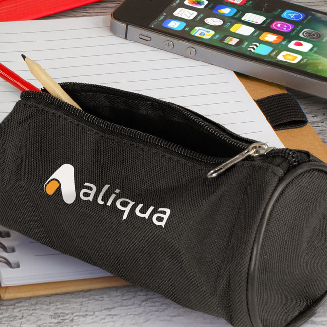 A black pencil case with a zip, featuring a logo, holding a pencil and placed on a notepad next to a smartphone.