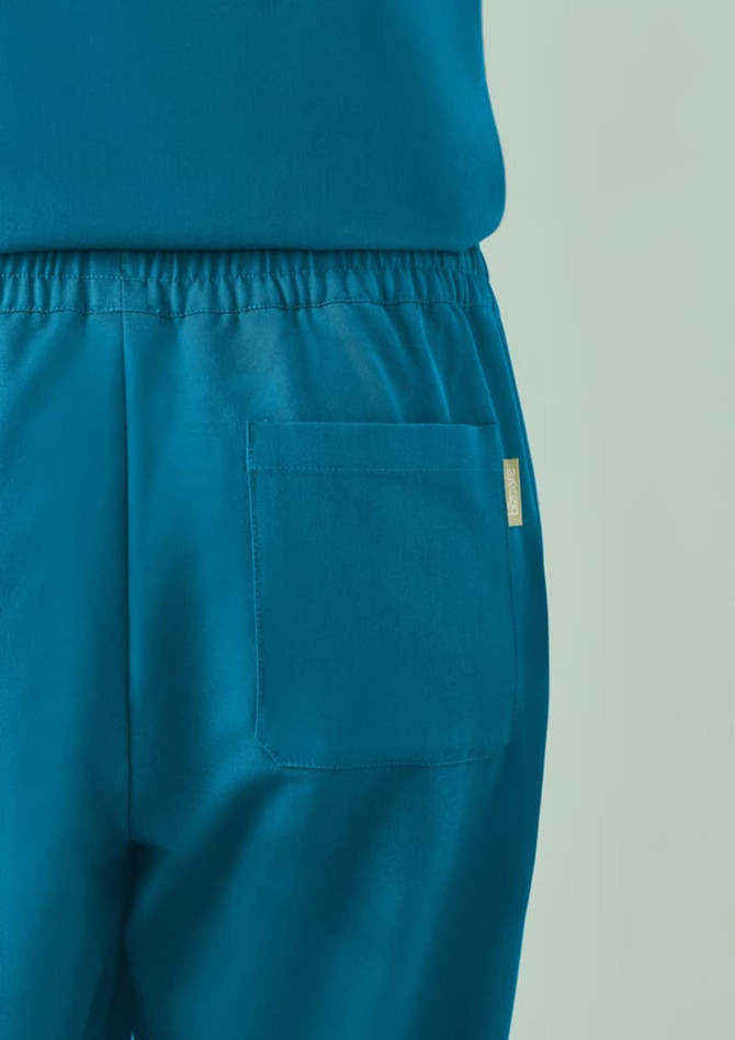 A pair of women's jogger scrub pants in teal, featuring a back pocket and an elastic waistband.