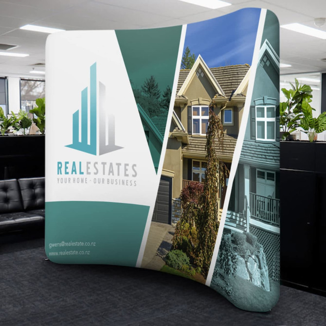 A curved stretch media wall featuring green and white sections with a logo and images of houses.