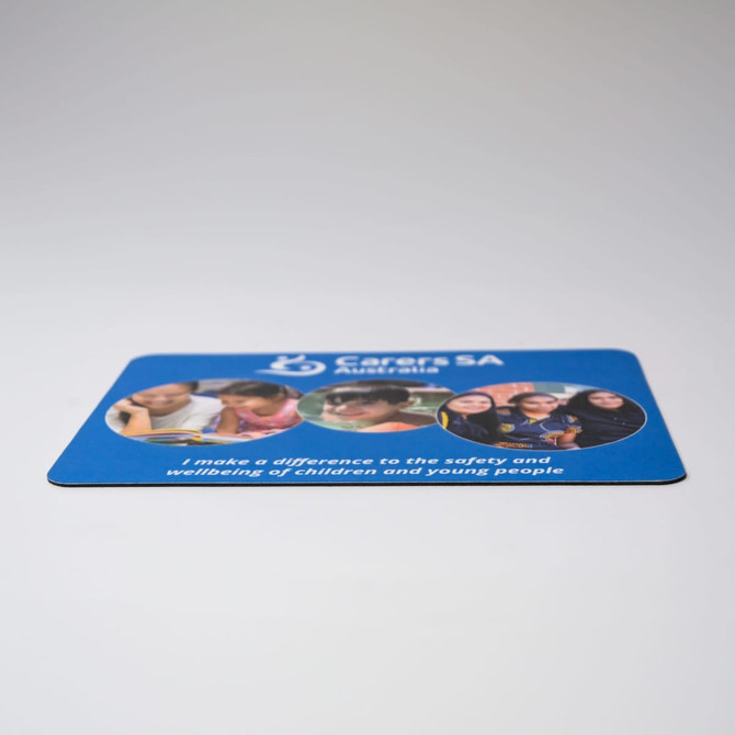 A blue mouse mat featuring images of children and young people, with a logo and text about safety and wellbeing.