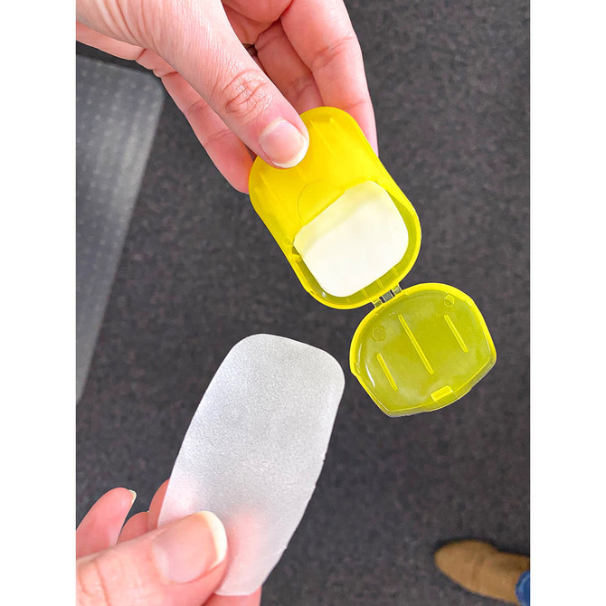 A yellow container holding a translucent soap-like product, with the lid partially open.