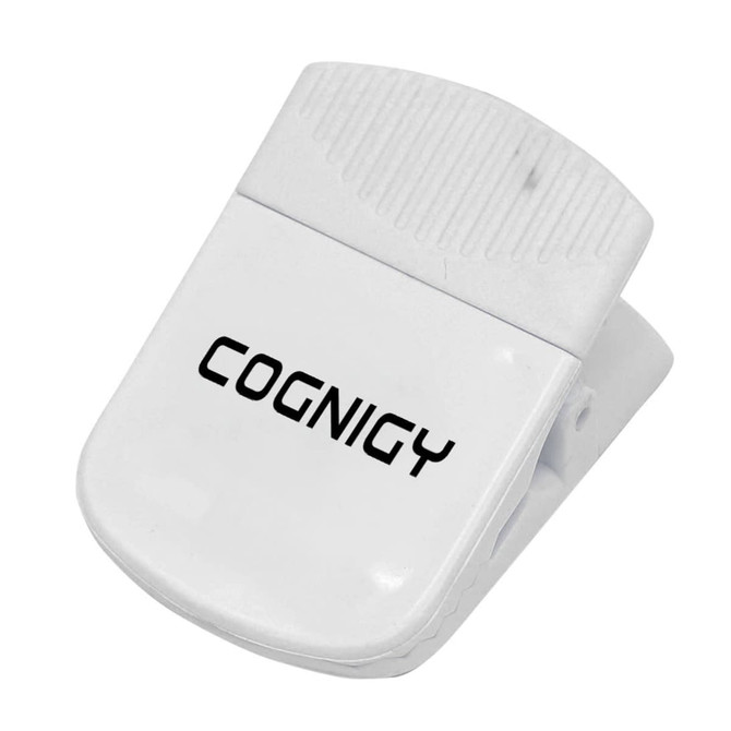 A white magnetic clip with a textured grip and a logo, designed for holding papers or other items.