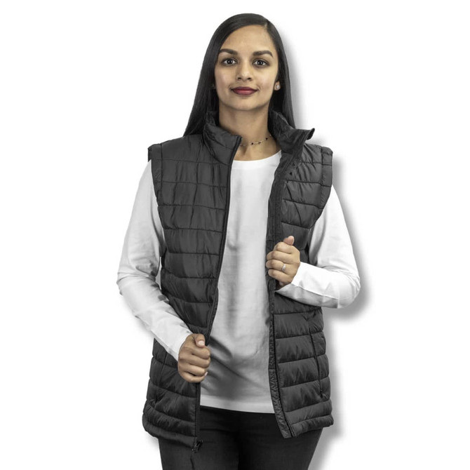 A woman models a black TRENDSWEAR Frazer women's puffer vest, featuring a zip front and high collar.