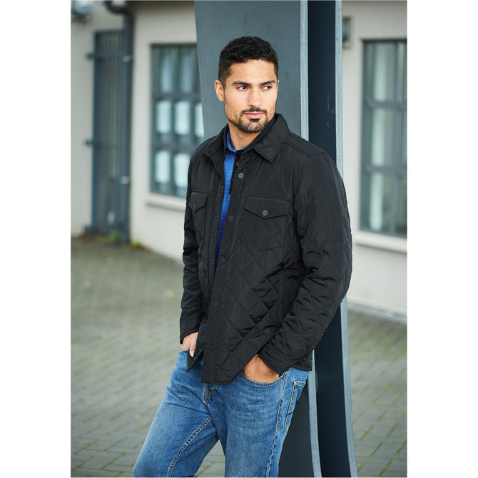 A black quilted jacket with a collared neck, worn by a man, paired with blue jeans. It features a brand logo.