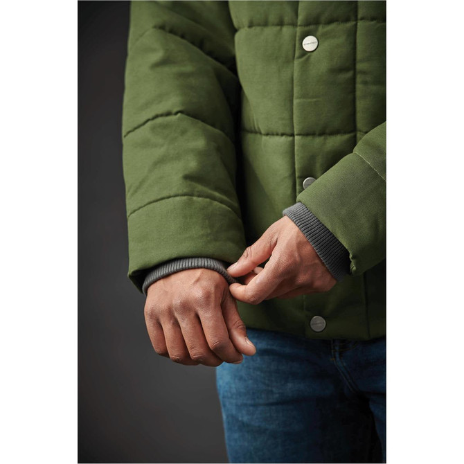 A green thermal jacket with a quilted design, featuring a cuffed sleeve and a visible logo.