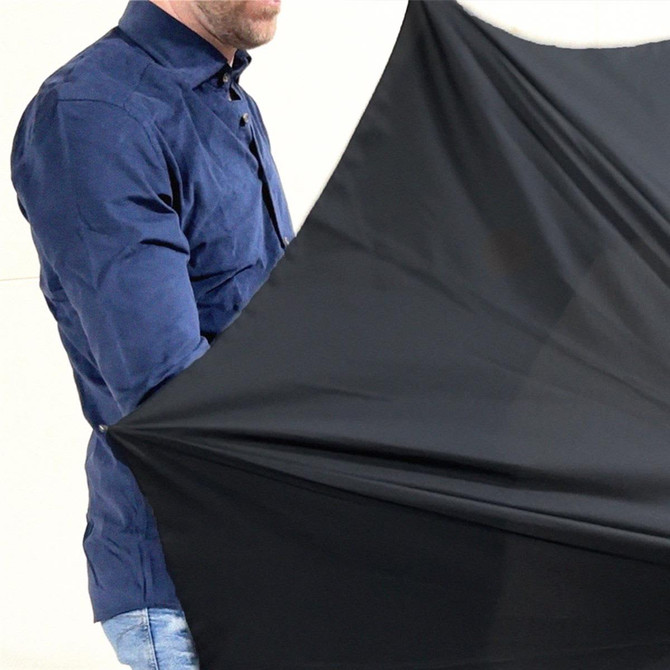 A black umbrella being held by a person, featuring a solid colour design and a sleek style.