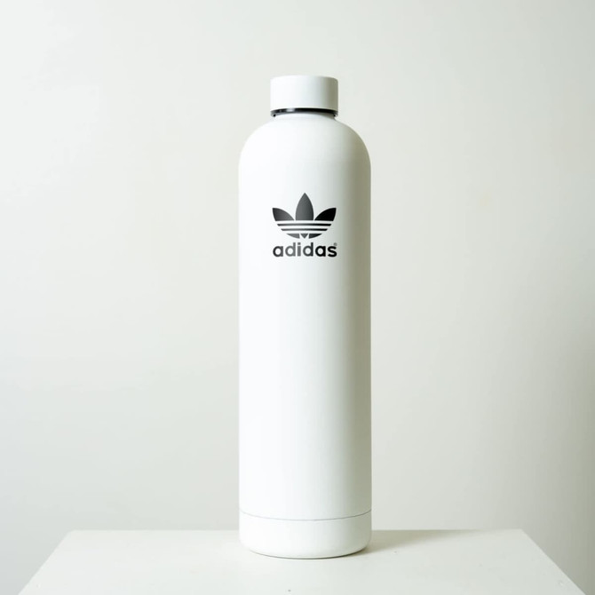 A drink bottle in a sleek white design with a black logo. It features a smooth, cylindrical shape.