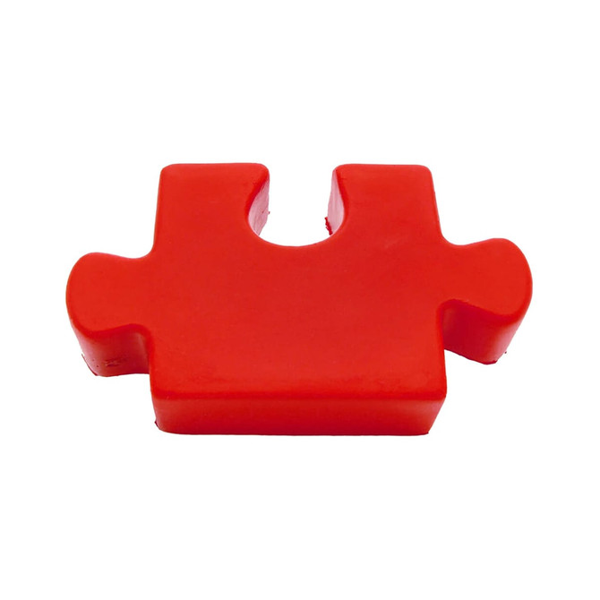 A red jigsaw puzzle piece, made of rubber, featuring a smooth surface and rounded edges.