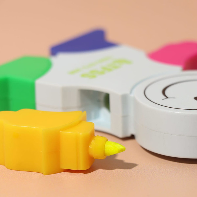 A set of highlighters in various colours, including yellow, pink, green, and blue, featuring a circular white casing with a logo.
