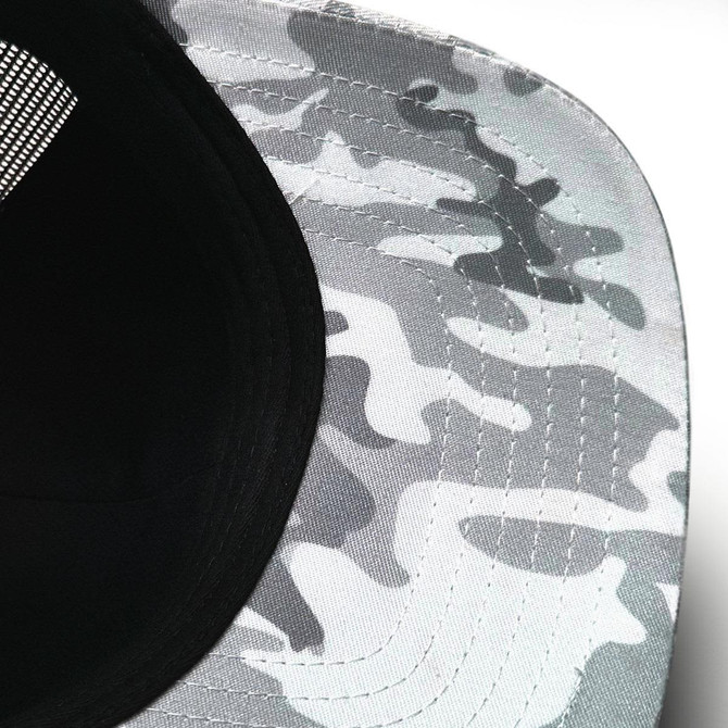 A trucker cap featuring a snow camouflage pattern in shades of grey, with a black mesh back and a branded logo.