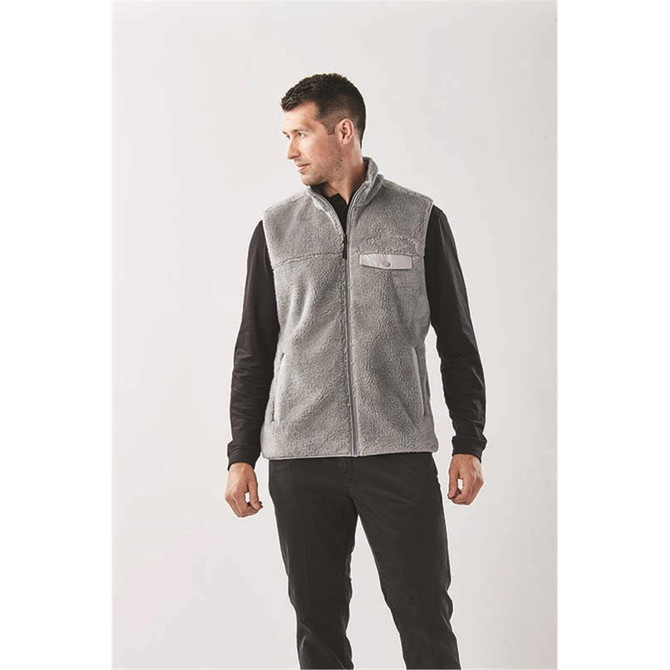 A men's vest in grey sherpa fleece, featuring a zip front and a logo detail, set against a light background.