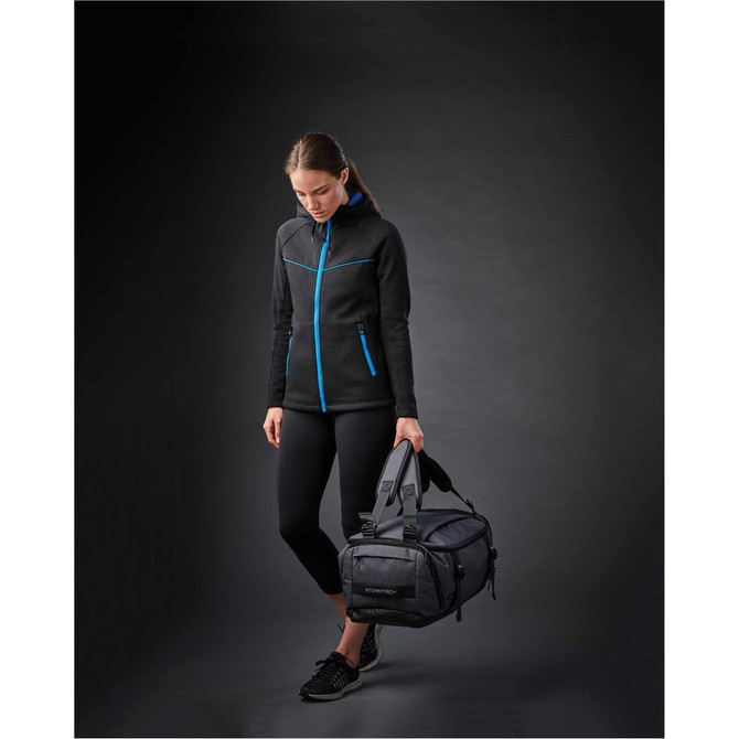 A black duffel bag with blue accents, held by a person wearing a black jacket and leggings.