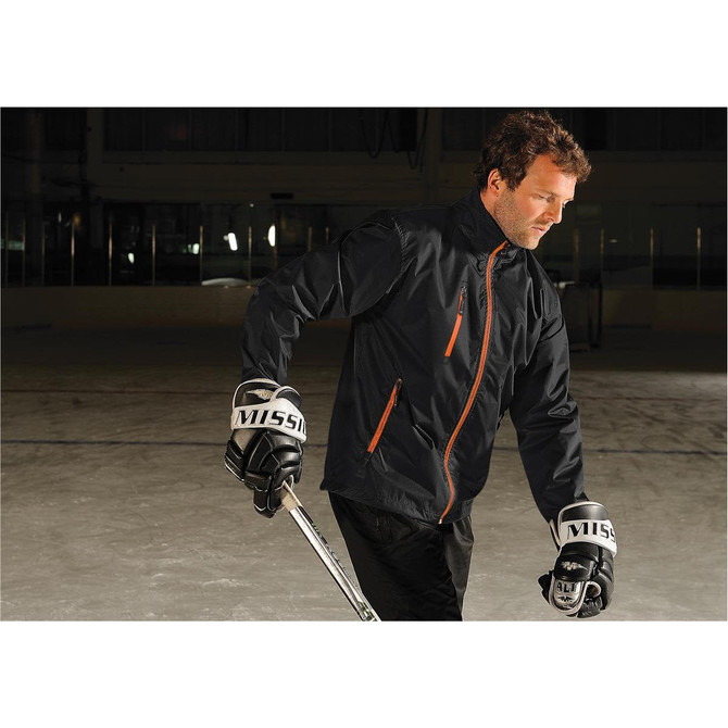 Men's Axis Thermal Jacket in black with orange accents, worn by a person on an ice rink, holding a hockey stick.