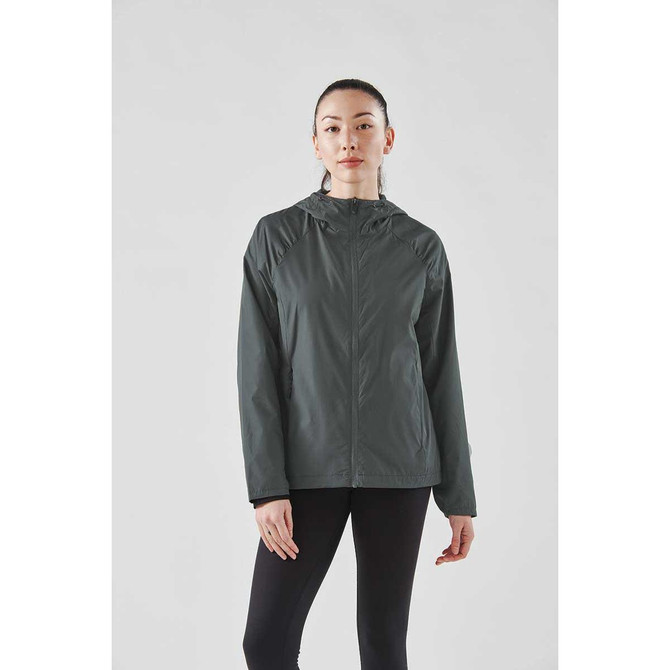 A woman in a dark green rain jacket with a lightweight design, featuring a hood and a branded logo.