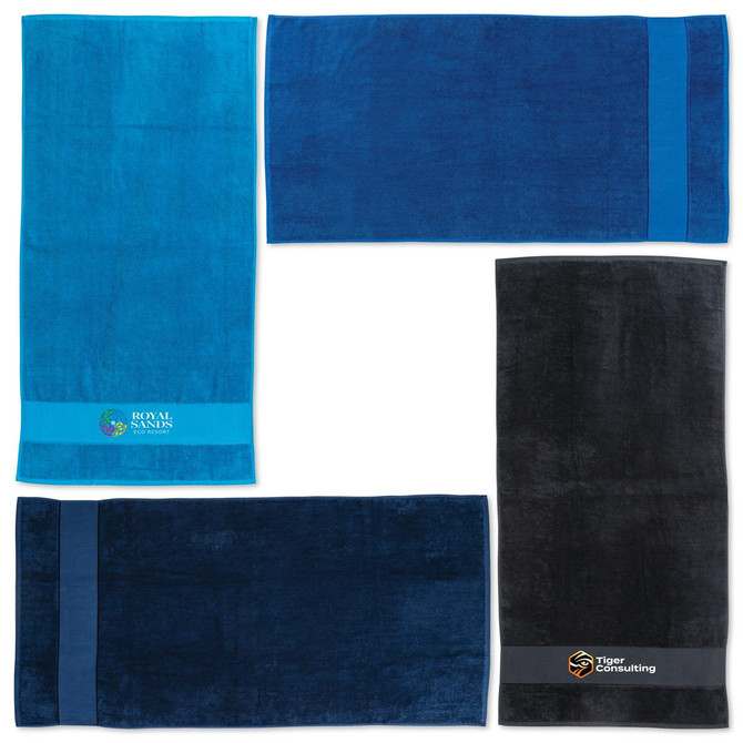 A set of four beach towels in shades of blue and black, featuring logos and branding on some.