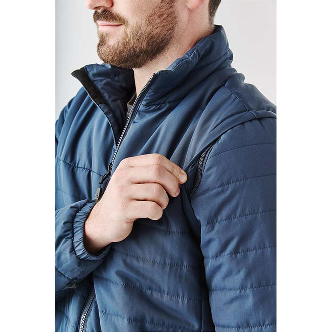 A man adjusts a navy blue Men's Fairbanks 5-in-1 System Jacket, featuring a zipped pocket on the sleeve.