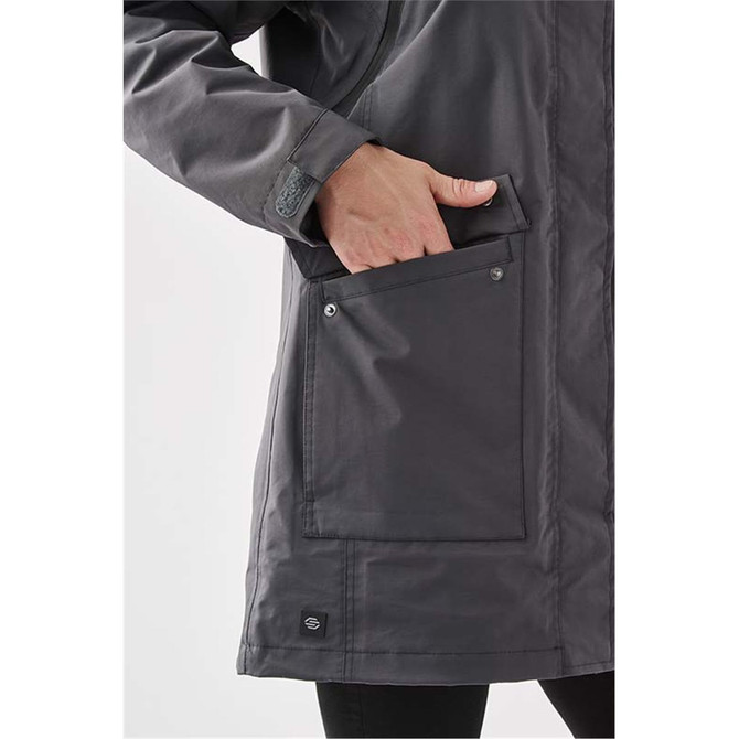 A grey Women's Fairbanks 5-in-1 System Jacket with a hand in a front pocket. The jacket features a logo.