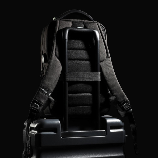 A black Swissdigital Arosa Backpack rests on a suitcase, featuring straps and a sleek design.