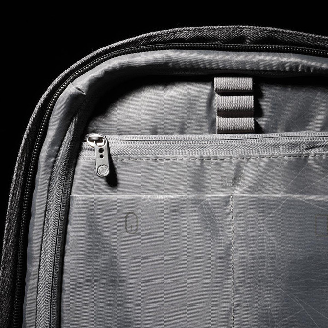 A grey backpack interior features zippered and compartmental storage with ergonomic design elements.