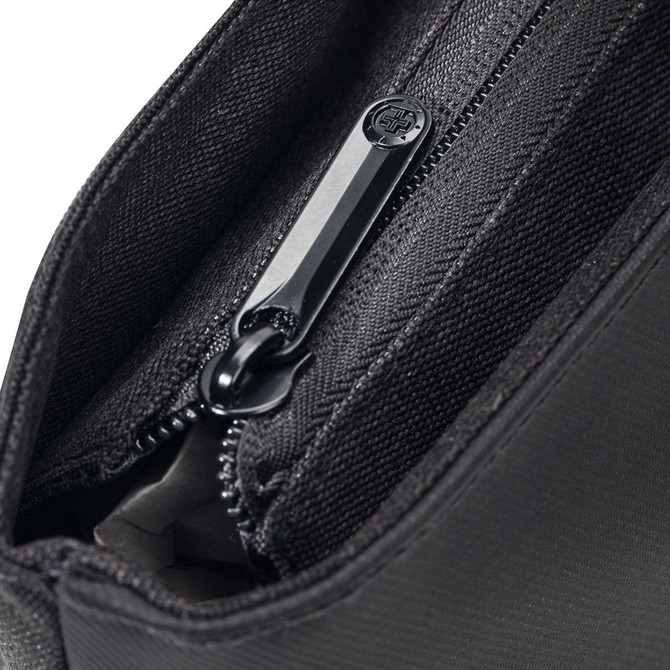 A close-up of a black tote bag's zippered pocket, showcasing its fabric texture and zipper details.