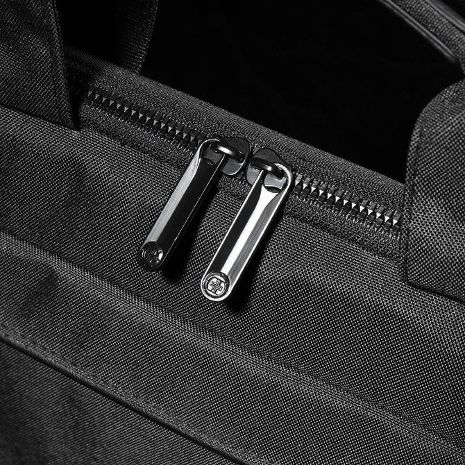 A black laptop sleeve with dual zippers, featuring a sleek and textured fabric design.