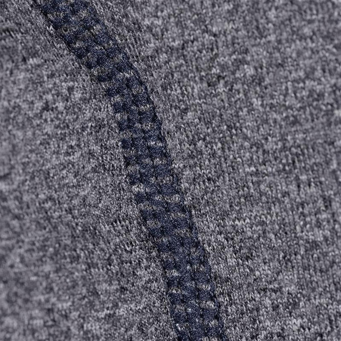 A close-up of a textured grey fabric with a contrasting navy seam, featuring a logo.