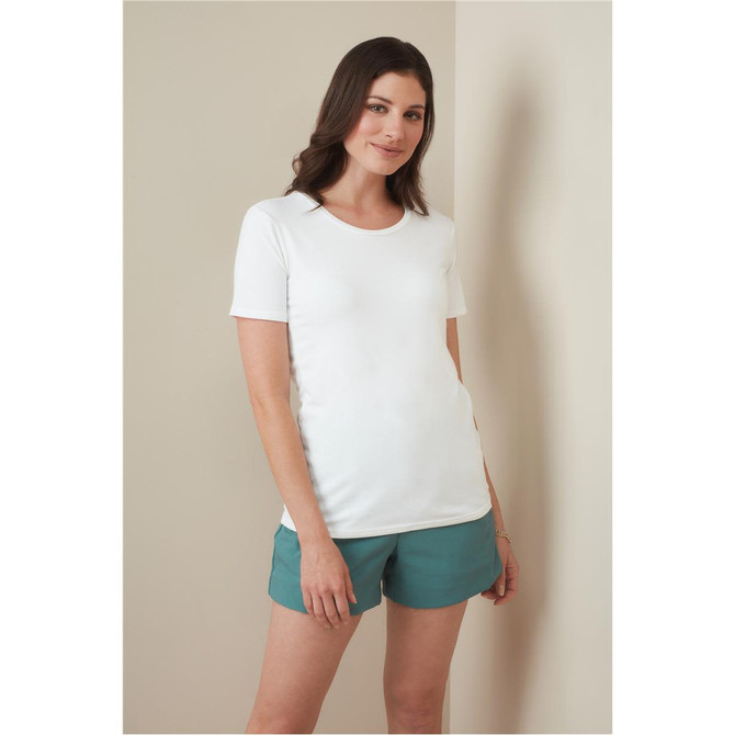 A woman stands wearing a white crew neck t-shirt paired with teal shorts. The shirt features a logo.