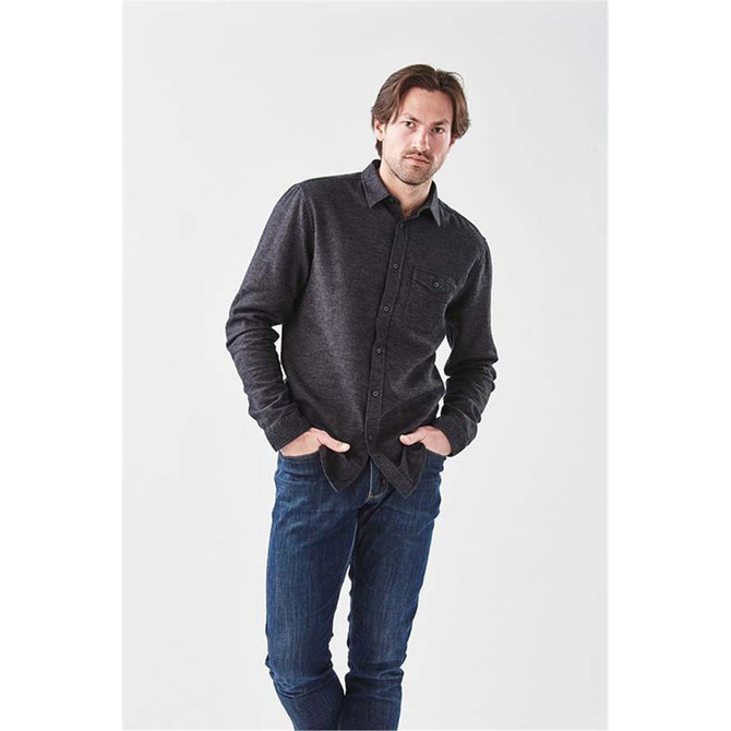 A long sleeve twill shirt in dark grey, featuring a button-up front and a chest pocket, worn with jeans.