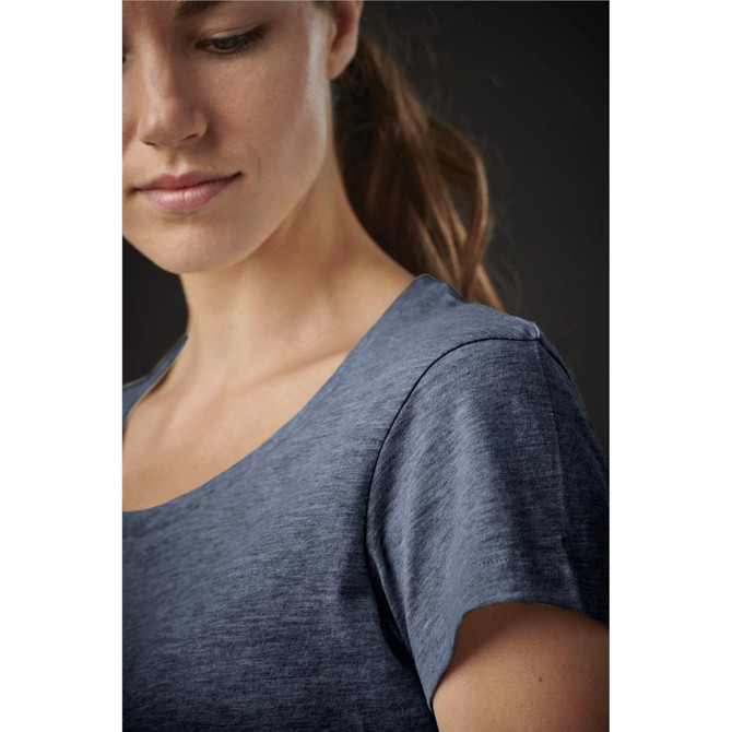 A close-up of a woman in a navy blue crew neck T-shirt with a smooth texture and a subtle logo.