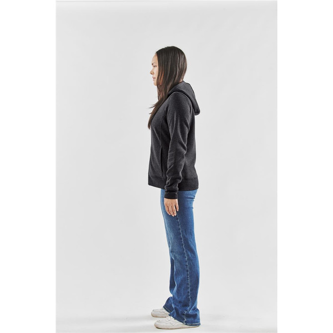 A woman in profile wearing a black fleece full zip hoodie and blue jeans, standing against a white background.