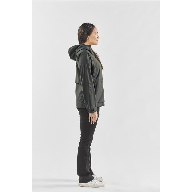 A woman is standing in profile, wearing a dark green rain jacket with a hood and pockets.