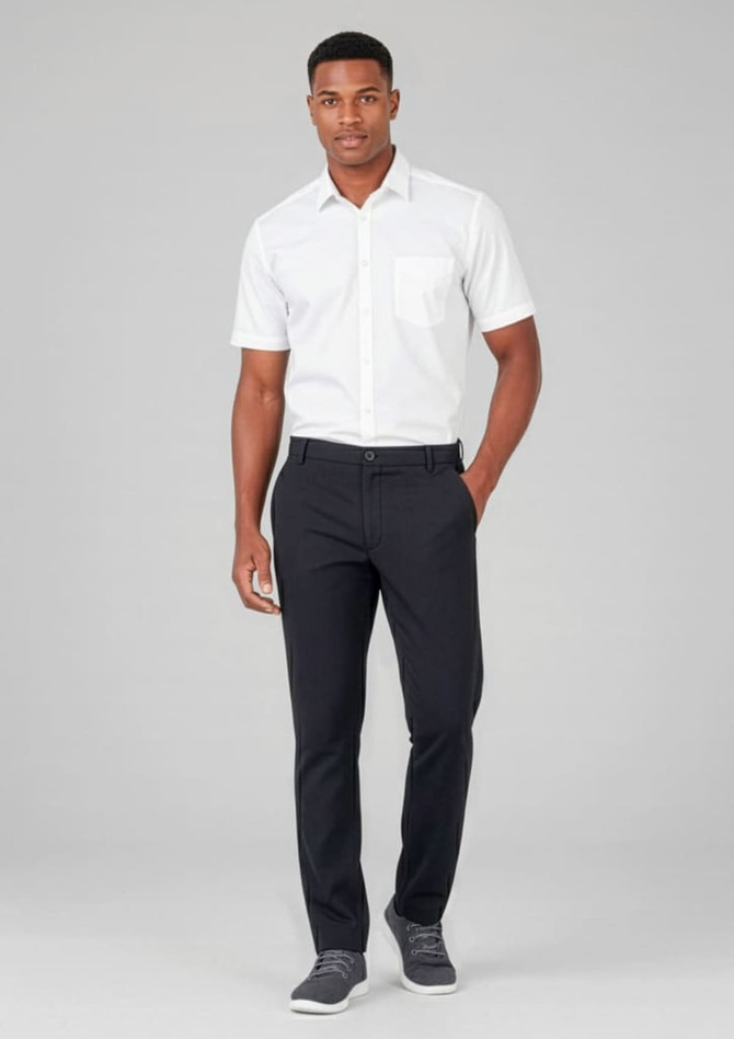 A man in a white shirt and black slacks, standing against a neutral background. The slacks have a flat front and feature a logo.