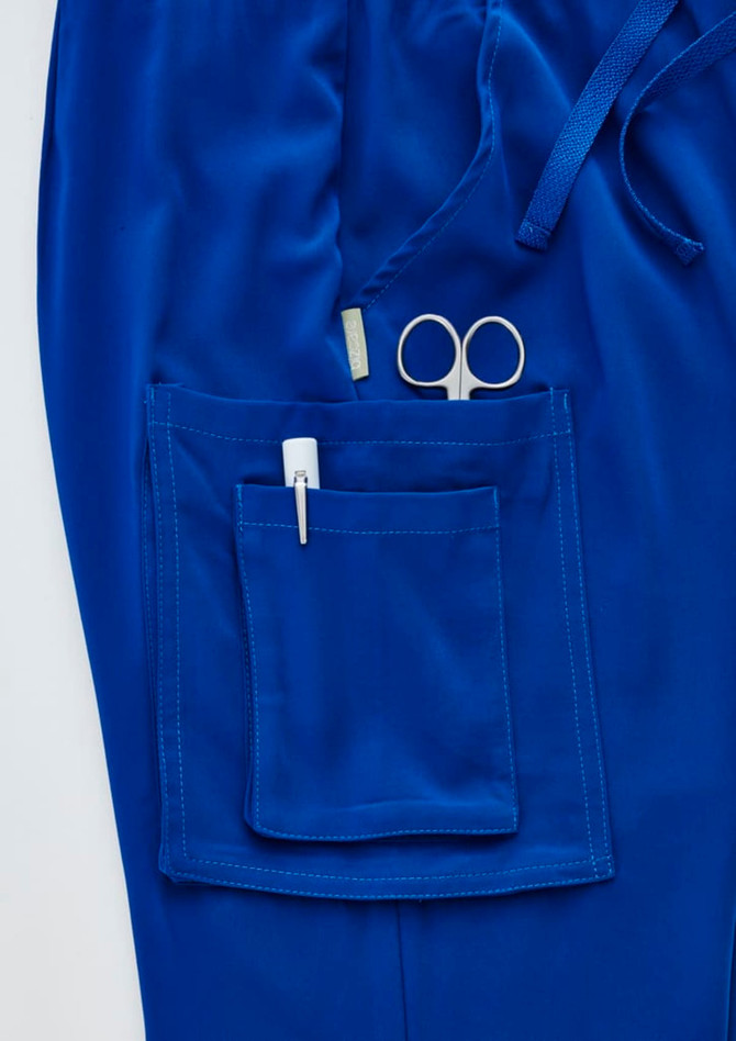A pair of royal blue straight leg scrub pants featuring a large pocket with scissors and a pen.