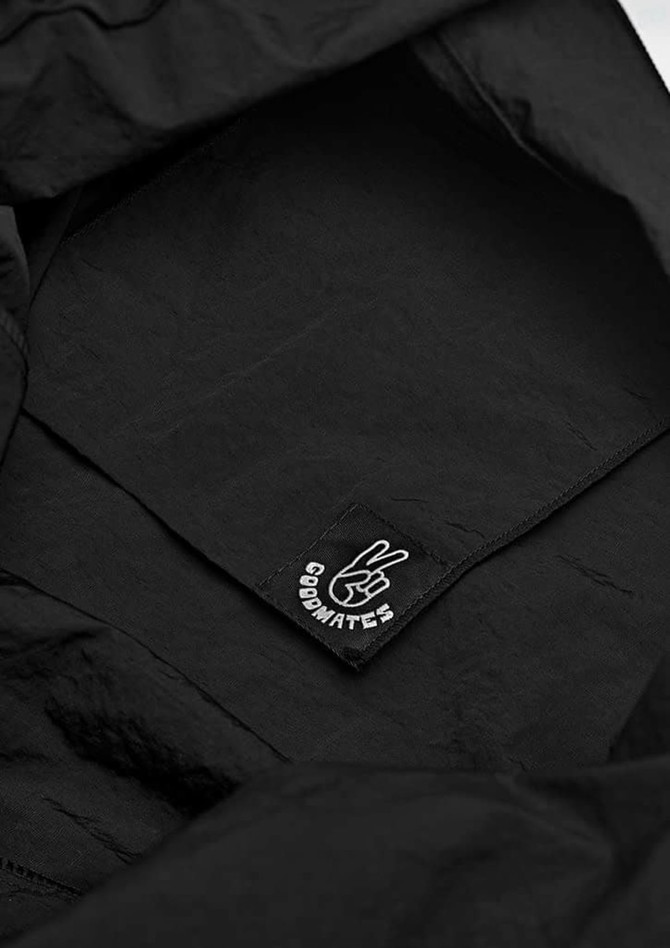 A black tote bag with a simple inner tag featuring a logo, showcasing a minimalist design.